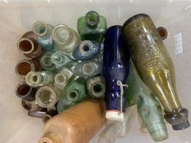 A box of vintage glass bottles including medicine