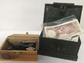 A small metal box containing used bank notes and m