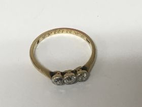 A Gold ring set with three old cut diamonds.