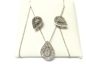 A silver pendant and earring set with white stones