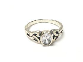 A silver Celtic style ring set with an oval white