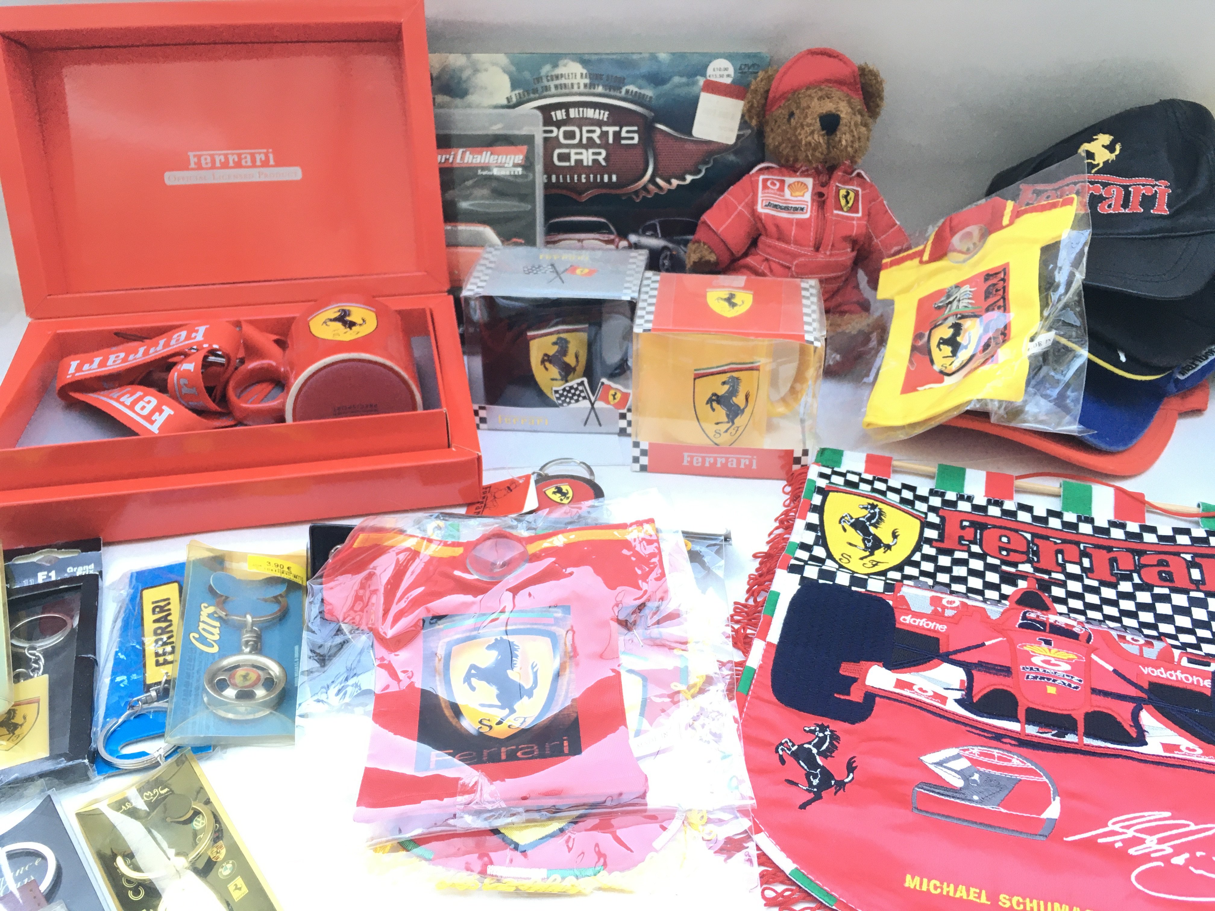 A Collection of Ferrari Merchandise. Including Magazines. Mugs.dvds. Key rings.caps. Glasses Etc.