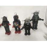 A collection of four toy robots. Two are tin plate