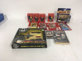 A collection of Batman related items including diecast vehiclesâ€¦collectors cards..surprise tins