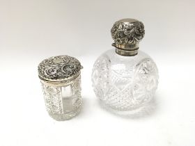 A silver perfume bottle with a silver tidy jar. CA