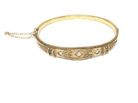 A 15ct gold bangle set with three diamonds. Approx