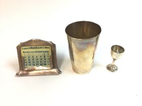 A collection of silver items including a calendar