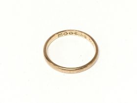 A 9ct gold band. Size P and 1.80g