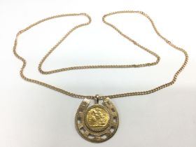 A 1967 gold sovereign in a gold horseshoe mount an