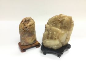 Two carved soapstone ornaments raised on carved ha