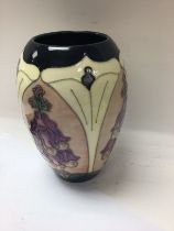 A Moorcroft vase decorated with foxglove 19 cm .