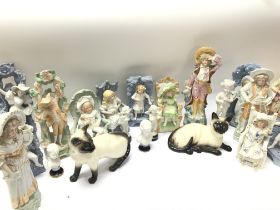 A collection of bisque figurines and Beswick cats.