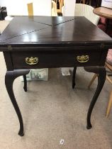 A Edwardian mahogany envelope card table with single drawer on cabriole legs .