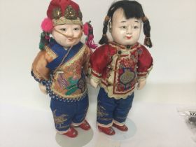 A pair of Chinese dolls in traditional costume dre