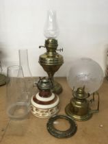 A brass oil lamp with shade and assorted parts