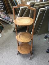 An oak three tier folding cake stand. Shipping category D.