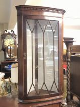 A reproduction hanging corner cabinet with glass s