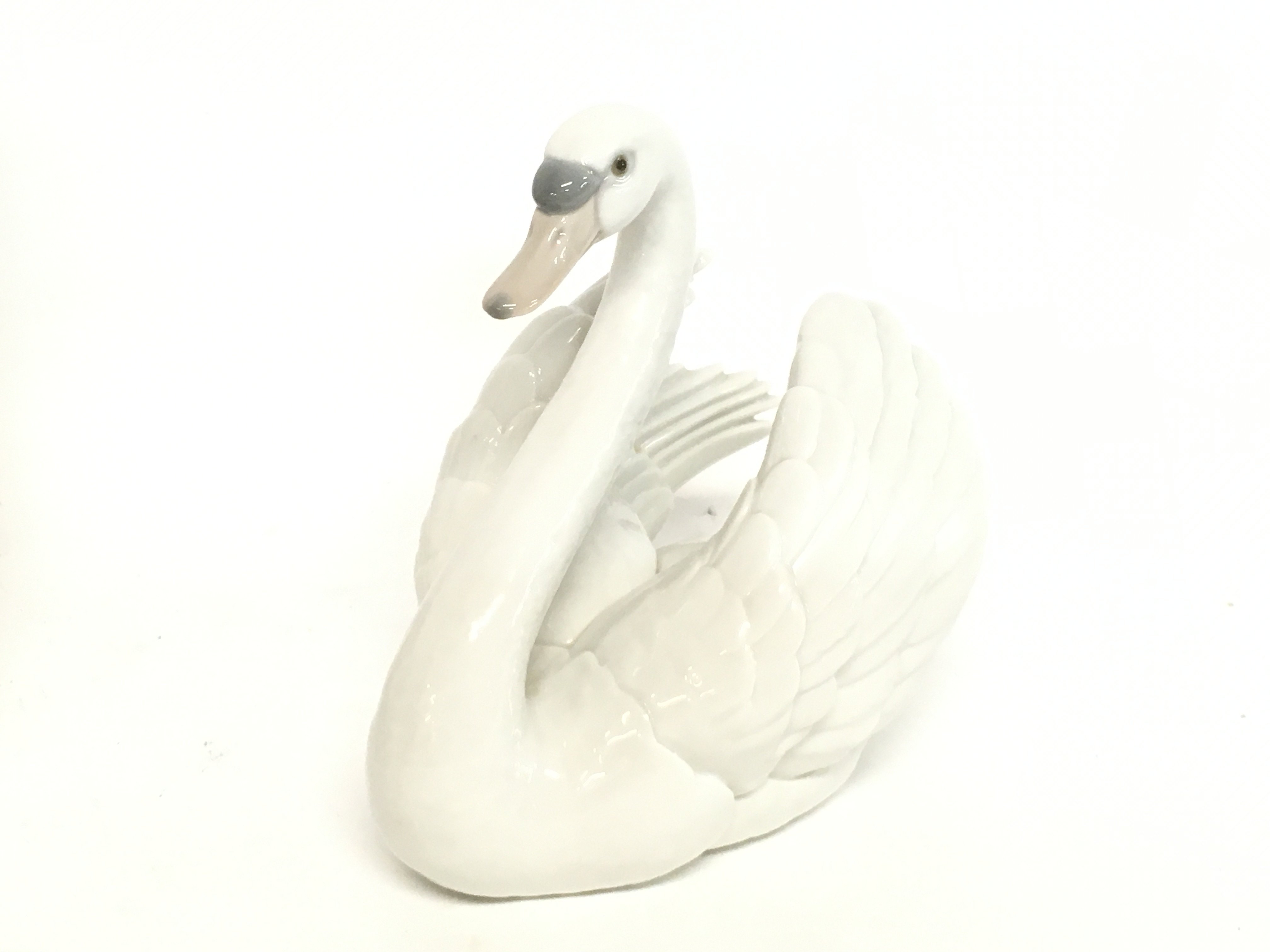 A Porcelain Lladro swan figure, 18cm tall. no obvi