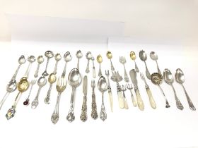 A collection of assorted silver spoons and folks. Including mother of Pearl and silver items and