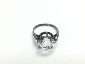 A silver ring set with a large clear stone, approx