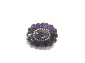 A yellow metal brooch set with amethyst and seed p