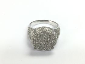 A large silver pave ring set with many white round