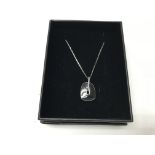 A 14ct white gold necklace with a black enamel pen