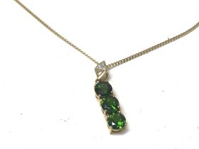 A 9ct gold chain with green stone set pendant. 4.2