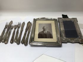 Two silver photo frames and a small collection of