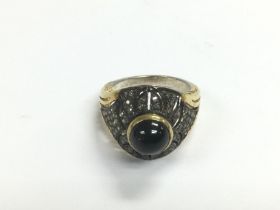 A silver gilt ring set with a cabochon sapphire an