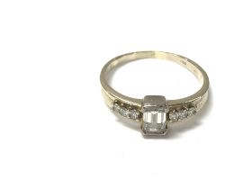 A 14ct gold ring set with a baguette diamond and s