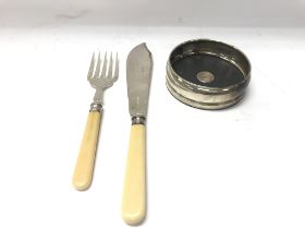 Silver fish slice and fork and a silver wine coast