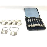 A collection of silver items including case silver Shakespeare spoons four napkins rings and a