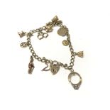 A 9ct gold charm bracelet with assorted charms. To