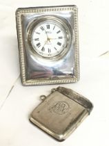 A silver vesta case and a silver cased clock. Post