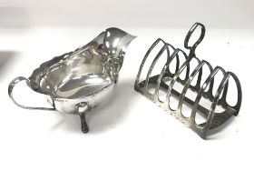 A silver toast rack and a silver jug both with She