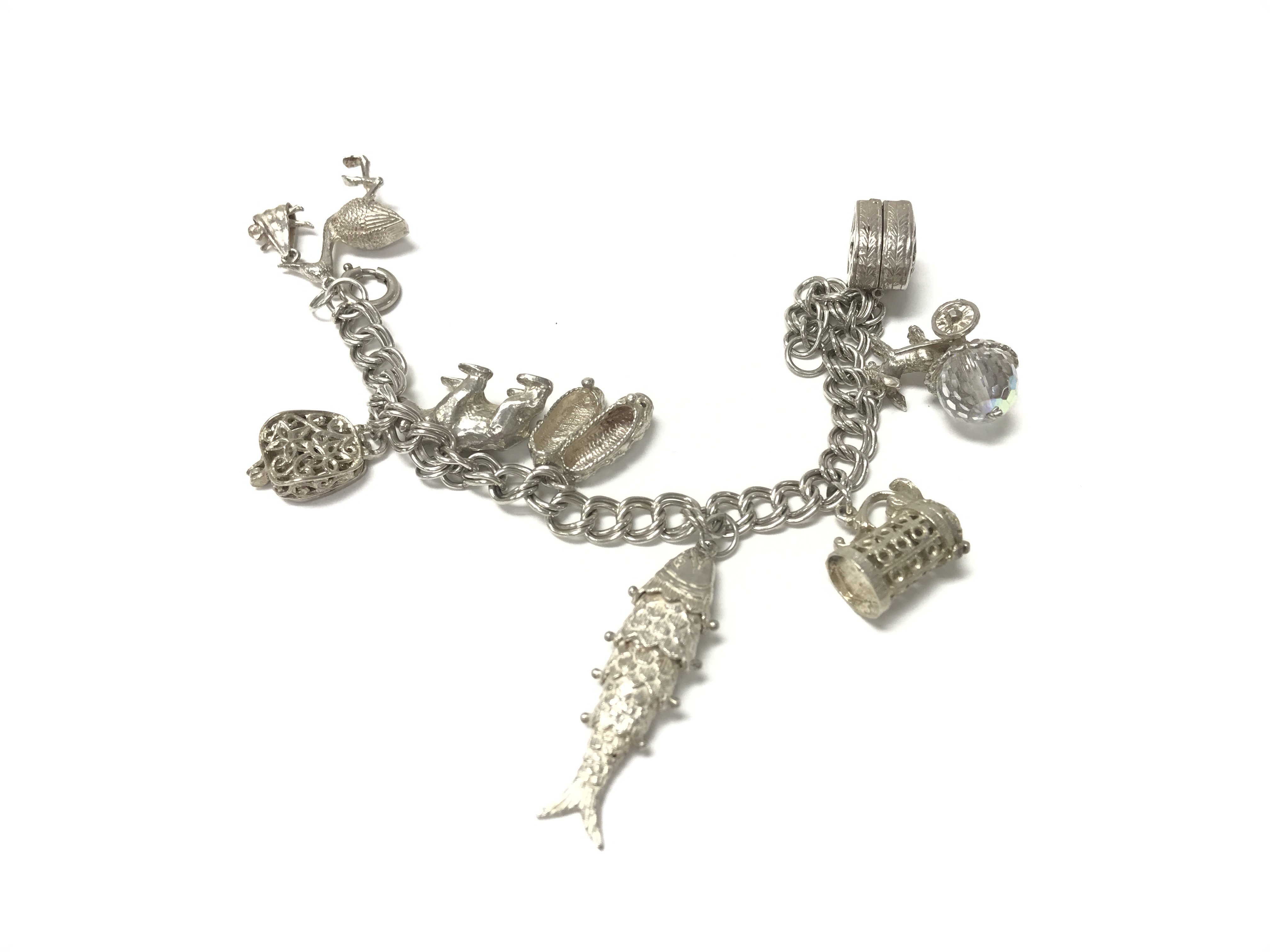 A silver charm bracelet with a number of charms. T