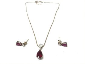 A silver earrings and pendant set which is set wit