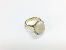 A 14ct gold ring set with a large oval white opal,