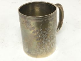 A small silver tankard engraved with a floral patt