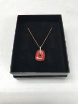 A 14ct gold necklace with a red enamel pendant. ap