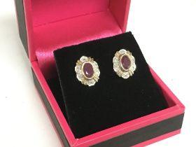 A pair of 9ct diamond and ruby earrings, 2.6g. Pos