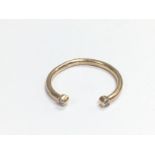 A 14k rose gold half hoop ring set with two small