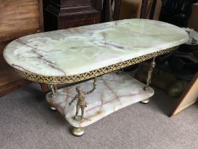 A Green Onyx gilt and brass coffee table supported by four Putto figures. Dimensions 47x107x45cm