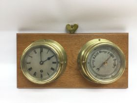 A wall mounted brass clock and barometer set. Ship