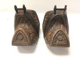 A pair of old carved possible South American stirr