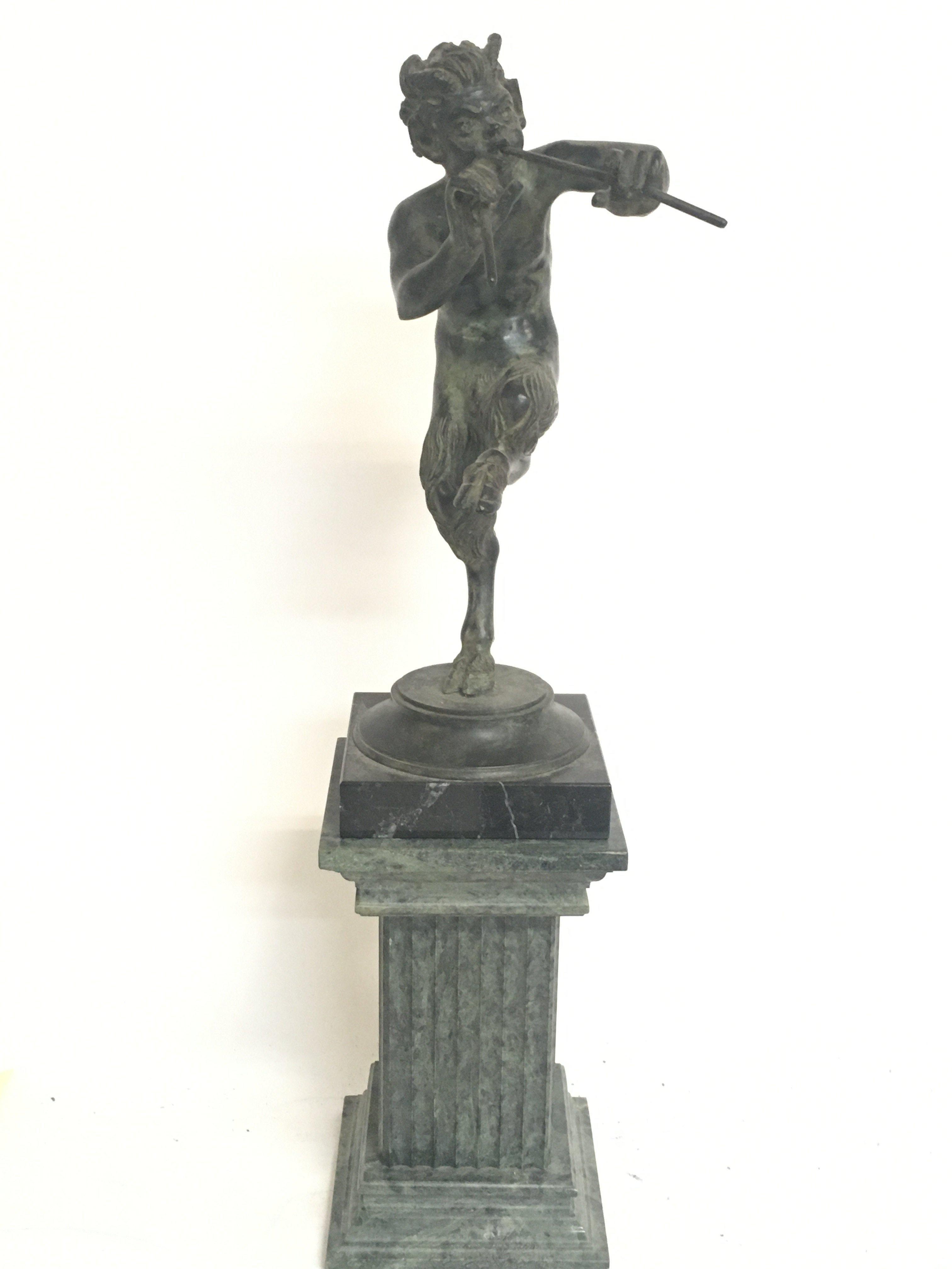 A bronze figure of Pan on a marble base, 42cm tall
