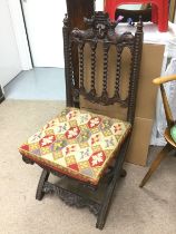 An elaborately carved chair with tapestry seat. Sh