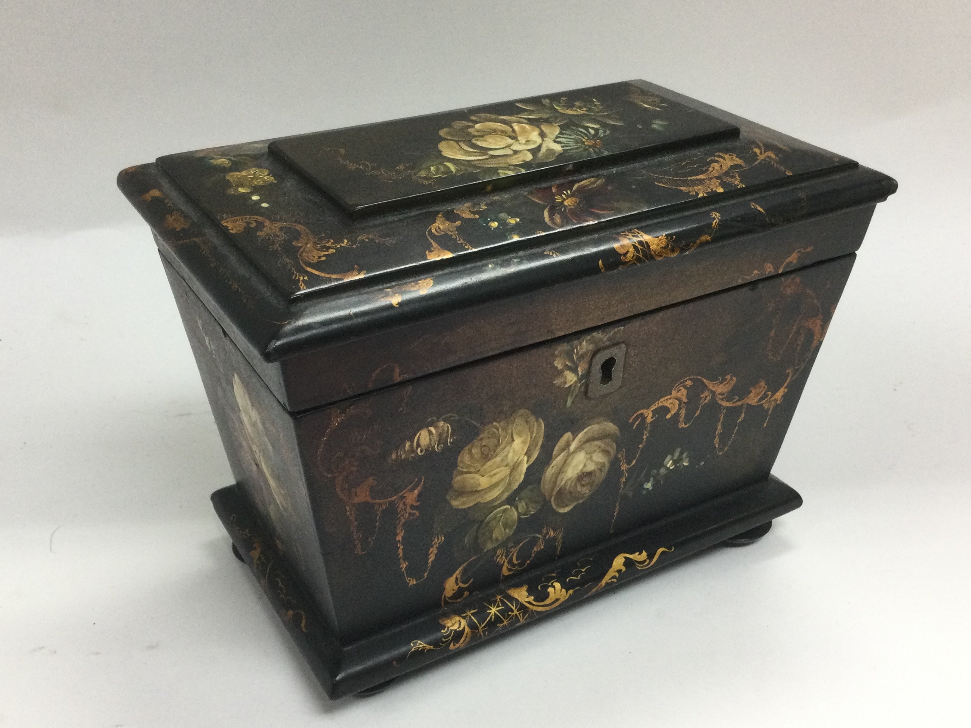 An ebonised box with hand painted giltwork and flo