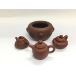 Four terracotta items comprising a pot and three m